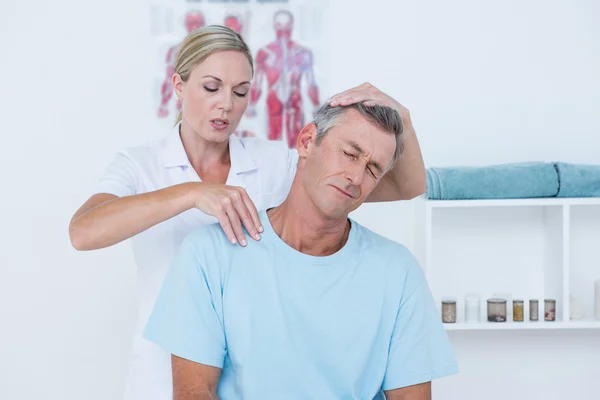 Médico examinando seu pescoço paciente — Fotografia de Stock