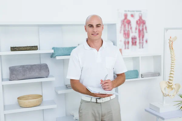 Feliz doctor escribiendo en el portapapeles — Foto de Stock