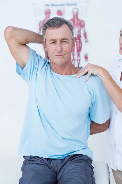 Doctor stretching a man arm — Stock Photo, Image