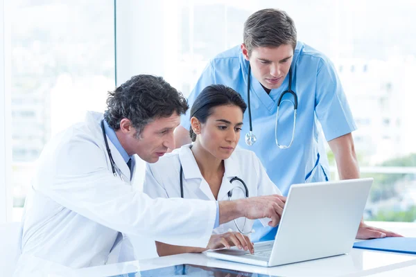 Team van artsen die werkzaam zijn op laptop — Stockfoto