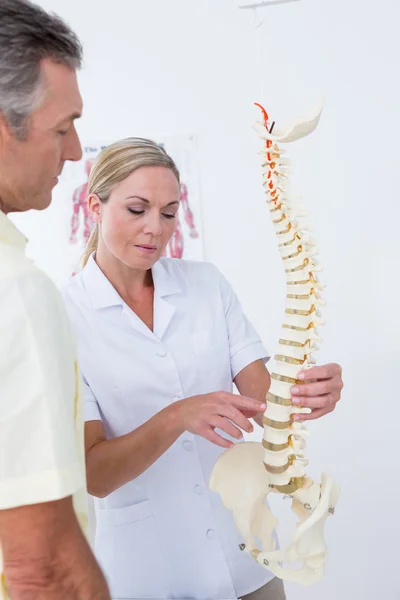 Doctor showing her patient a spine model — Stock Photo, Image