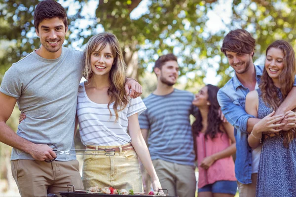 Amigos felizes no parque fazendo churrasco — Fotografia de Stock