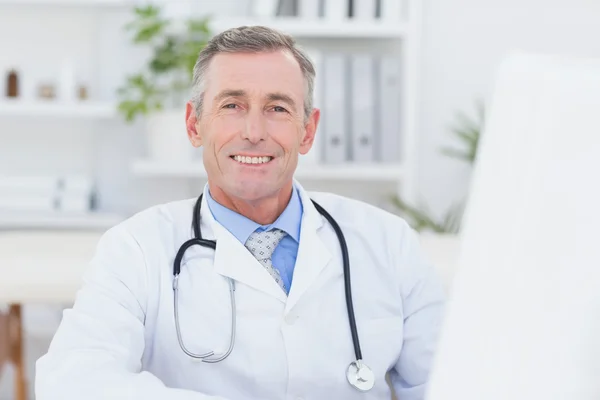 Usmívající se lékař se dívá do kamery — Stock fotografie