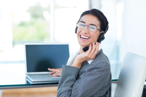 Donna d'affari sorridente che indossa un auricolare da lavoro — Foto Stock