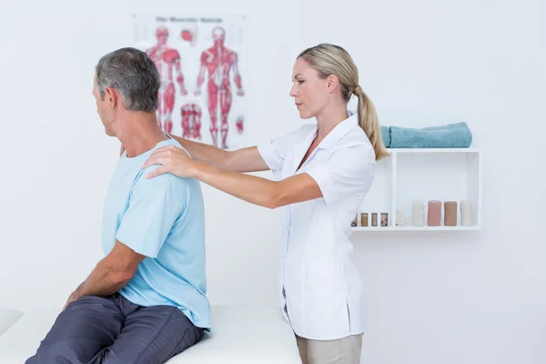 Médico examinando seu pescoço paciente — Fotografia de Stock