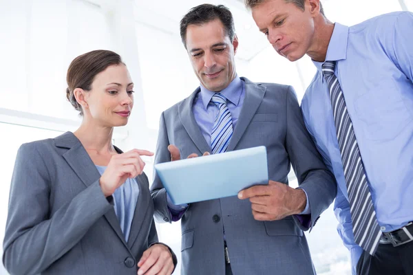 Businessman showing tablet to his colleagues — Stock Photo, Image