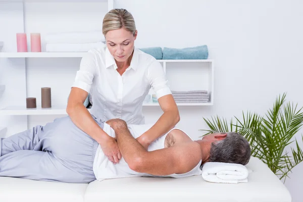 Fisioterapista che fa massaggi alle spalle al suo paziente — Foto Stock