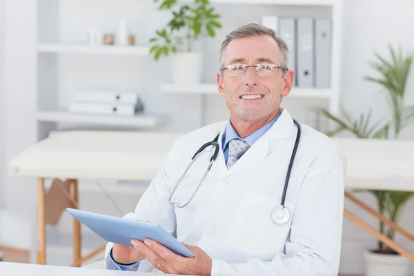 Médecin regardant la caméra avec presse-papiers — Photo