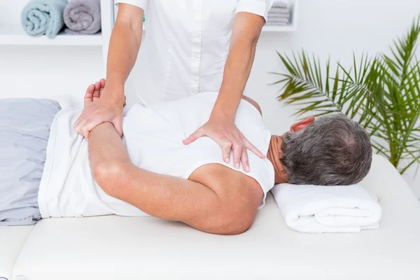 Fisioterapeuta fazendo massagem no ombro para seu paciente — Fotografia de Stock
