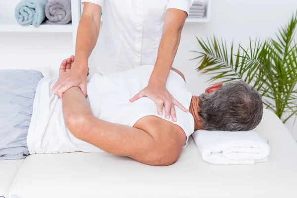 Fysiotherapeut schouder massage doen aan haar patiënt — Stockfoto