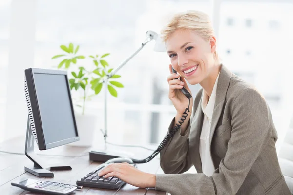 Empresária ao telefone e usando seu computador — Fotografia de Stock