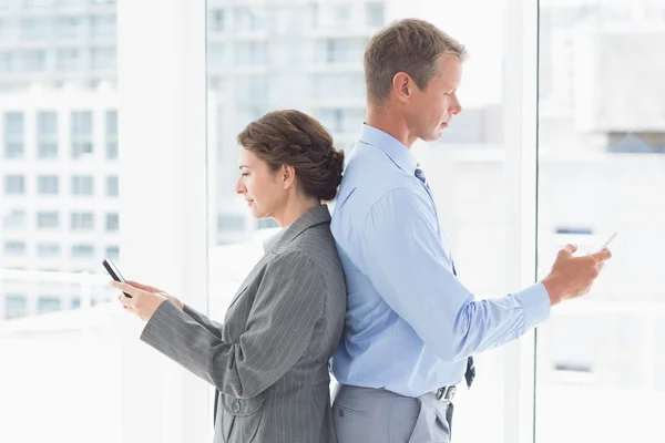 Businesswoman back-to-back with colleague — Stock Photo, Image