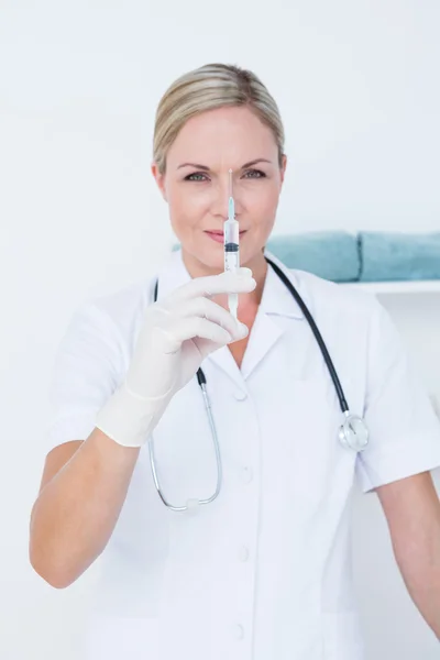 Médico mostrando seringa para câmera — Fotografia de Stock