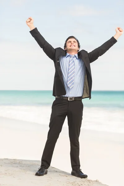 Happy businessman cheering at the beach — Stock fotografie