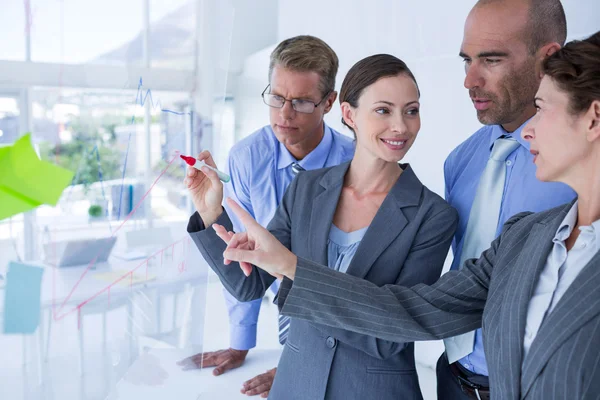 Geschäftsfrau zeichnet Grafik auf die Tafel — Stockfoto