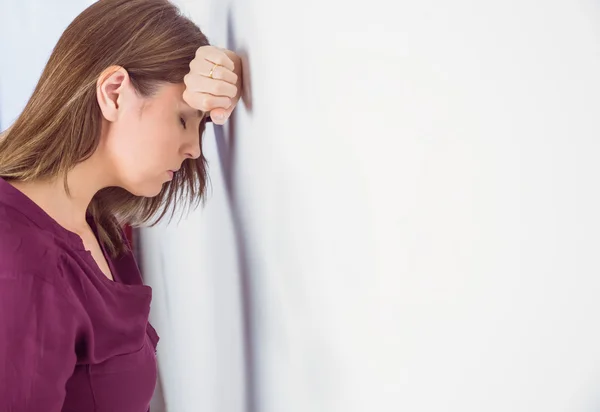 Депрессивная женщина прислонилась головой к стене — стоковое фото