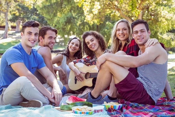 Amigos felices en el parque haciendo picnic —  Fotos de Stock