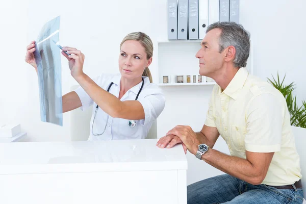 Doctor mostrando rayos X a su paciente — Foto de Stock