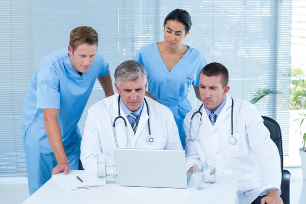 Equipo de médicos que trabajan en el ordenador portátil —  Fotos de Stock