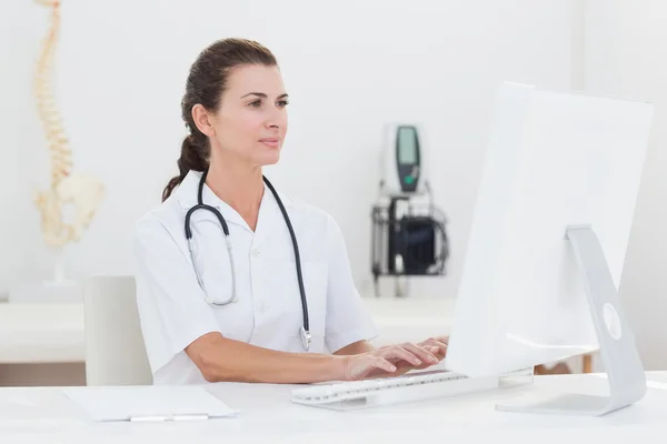 Концентрированная женщина-врач с помощью компьютера — стоковое фото