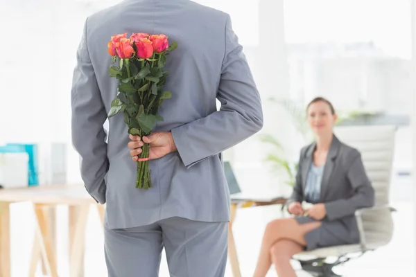 Homme d'affaires tenant des fleurs derrière le dos — Photo