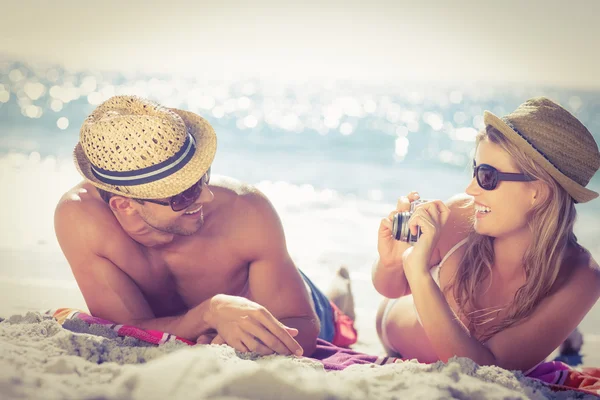 Linda pareja virando fotos en la playa — Foto de Stock