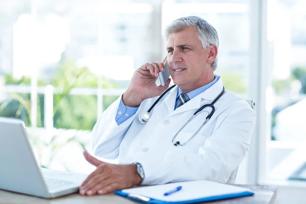 Médico ter telefonema na mesa — Fotografia de Stock