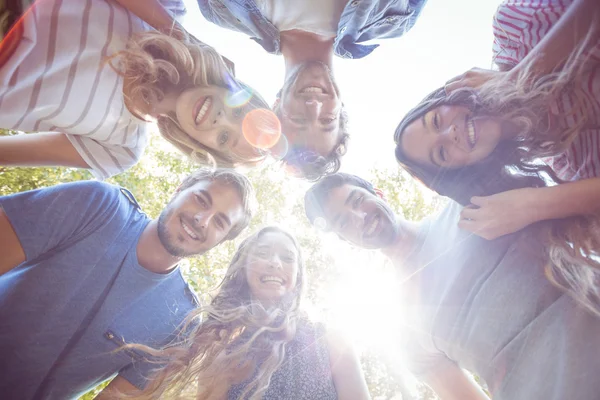 Happy vrienden huddling in cirkel in het park — Stockfoto