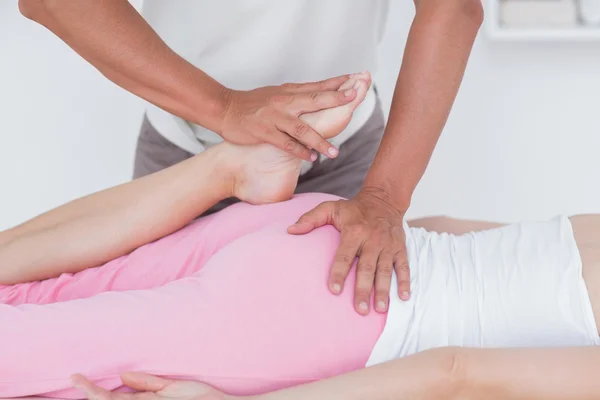 Fisioterapeuta haciendo masaje de piernas a su paciente — Foto de Stock