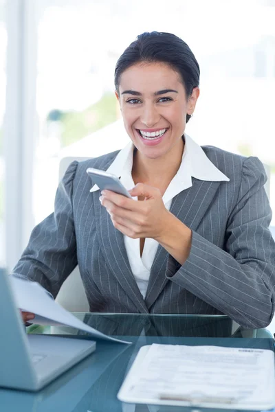 Mulher de negócios sorrindo usando smartphone — Fotografia de Stock