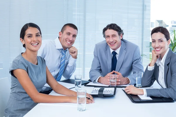 Smiling business team sitting at desk — Stock Photo, Image