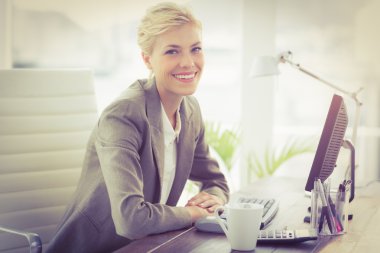 Smiling businesswoman looking at camera clipart