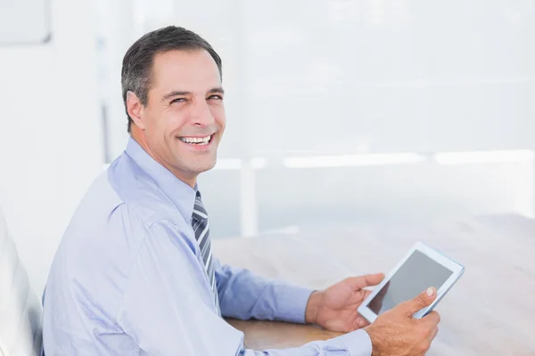 Empresário sorrindo usando tablet — Fotografia de Stock