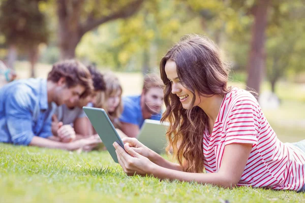Pretty brunette using tablet in the park — Stock Photo, Image