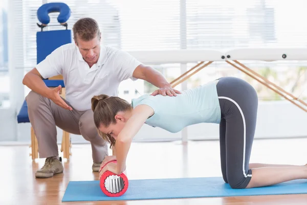 Trainer working with woman on exercise mat — Stock Photo, Image