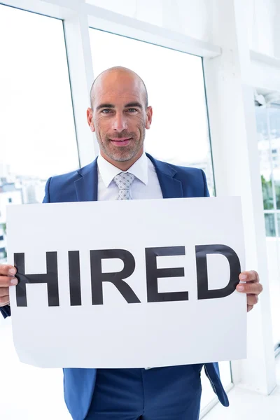 Businessman holding a hired sign — Stock Photo, Image