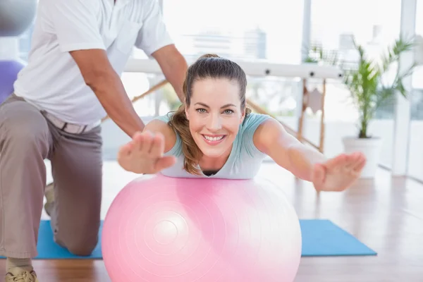Trainer care lucrează cu o femeie pe mingea de exerciții — Fotografie, imagine de stoc