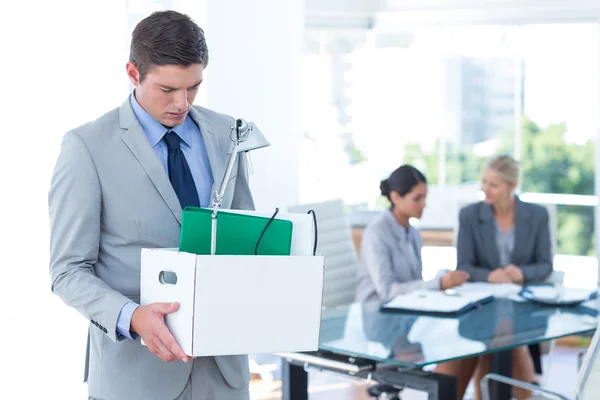 Businessman carrying his belongings in box