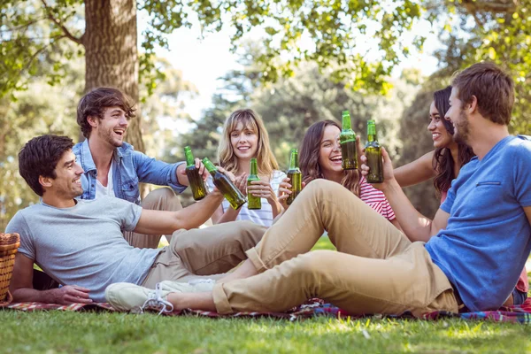 Amigos felizes no parque fazendo piquenique — Fotografia de Stock