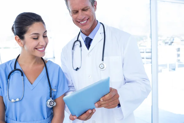 Happy doctors looking at clipboard — Stock Photo, Image