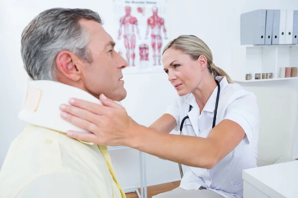 Arts onderzoeken patiënt dragen nek brace — Stockfoto