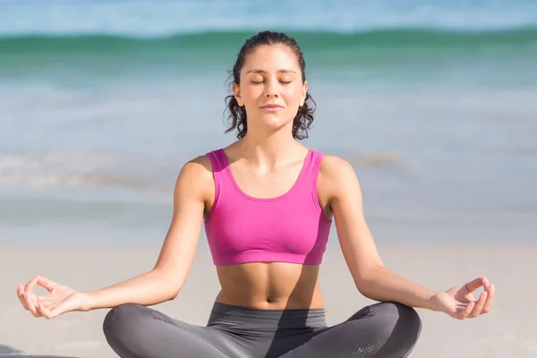 Mujer en forma haciendo yoga al lado del mar — Foto de Stock