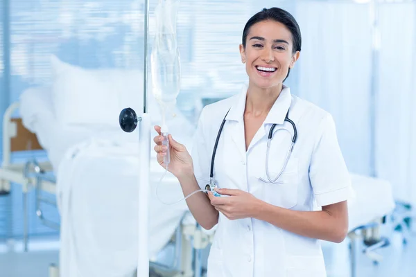 Enfermeira que liga um gotejamento intravenoso — Fotografia de Stock