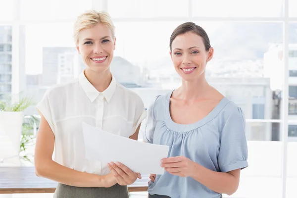 Mujeres de negocios sonrientes mirando a la cámara y trabajando juntas — Foto de Stock