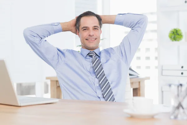 Homme d'affaires souriant relaxant au bureau — Photo