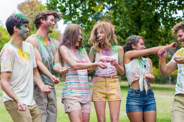 Glückliche Freunde, die mit Pulverfarbe werfen — Stockfoto