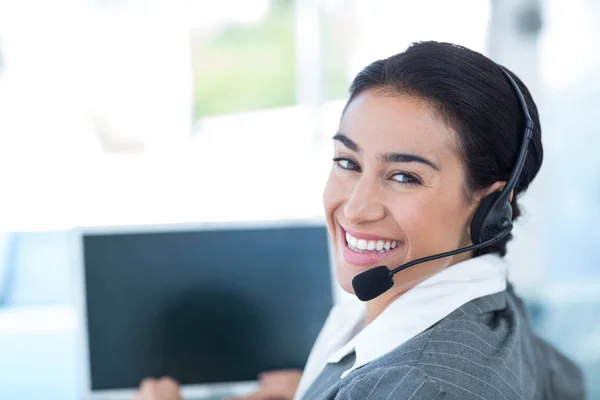 Mulher de negócios usando um fone de ouvido de trabalho — Fotografia de Stock