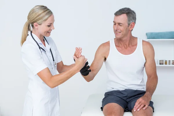 Doctor examining a man wrist — Stock Photo, Image