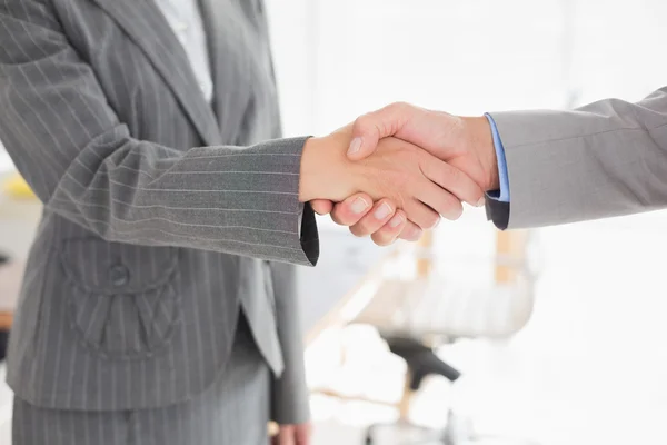 Empresária apertando as mãos com um homem de negócios — Fotografia de Stock
