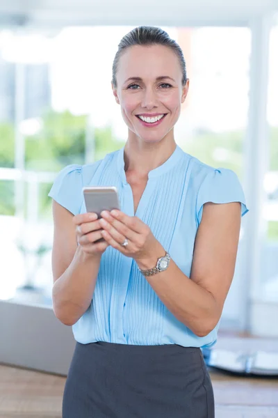 Leende affärskvinna med sin smartphone — Stockfoto